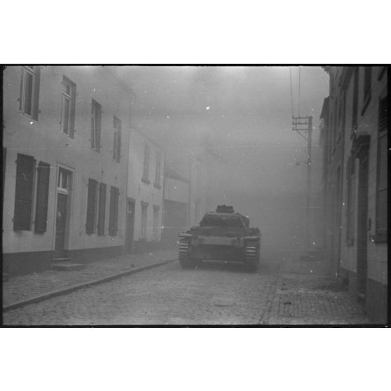 A Perwez en Brabant (Belgique), à l'issue de la bataille de France, un blindé Panzer-III de la 4e division blindée allemande (4.Panzer-Division) parade dans les rues de la ville pour les besoins de la propagande.