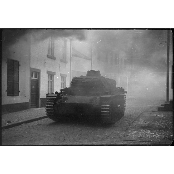 A Perwez en Brabant (Belgique), à l'issue de la bataille de France, un blindé Panzer-III de la 4e division blindée allemande (4.Panzer-Division) parade dans les rues de la ville pour les besoins de la propagande.