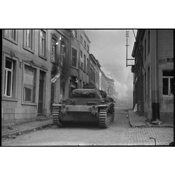 A Perwez en Brabant (Belgique), à l'issue de la bataille de France, un blindé Panzer-III de la 4e division blindée allemande (4.Panzer-Division) parade dans les rues de la ville pour les besoins de la propagande.