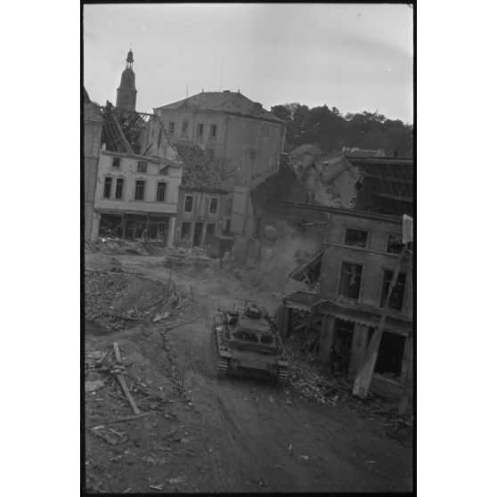 A Perwez en Brabant (Belgique), à l'issue de la bataille de France, un blindé Panzer-III de la 4e division blindée allemande (4.Panzer-Division) parade dans les rues de la ville pour les besoins de la propagande.