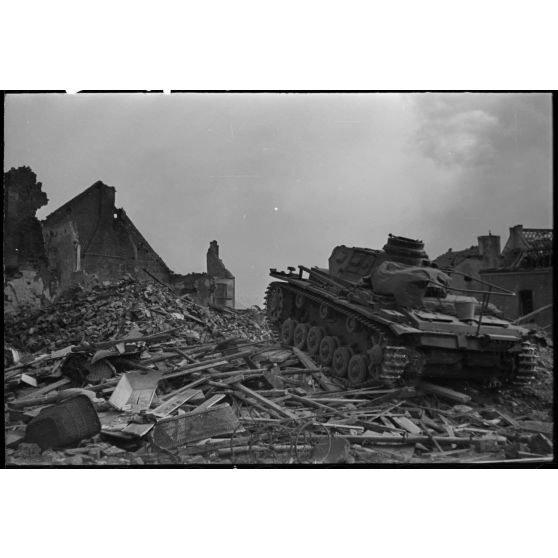 A Perwez en Brabant (Belgique), à l'issue de la bataille de France, un blindé Panzer-III de la 4e division blindée allemande (4.Panzer-Division) parade dans les rues de la ville pour les besoins de la propagande.