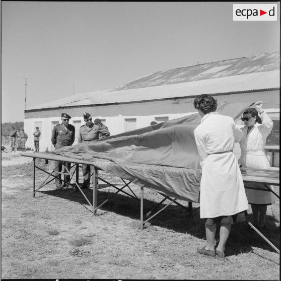 Général de brigade et commandant parachutistes observant des toiles de parachutes lors du 27e Congrès national des officiers de réserve à Constantine.