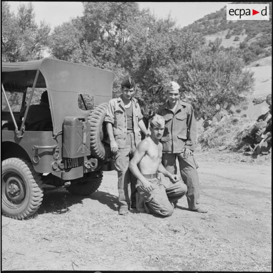 Soldats posant devant une Jeep au campement du QG régional des unités de la Xe région militaire participant à des manoeuvres à Yakouren.