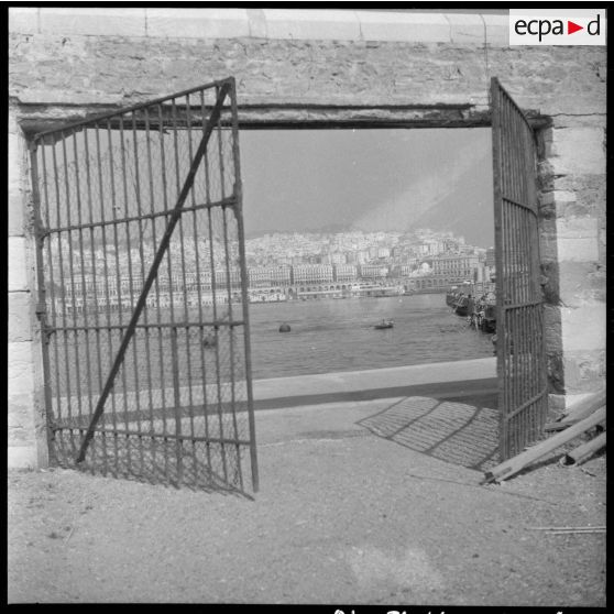 Grilles ouvertes sur le port et la ville d'Alger.