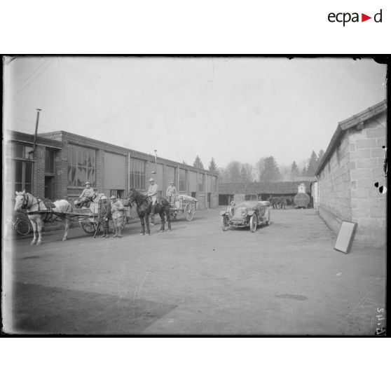 [Soldats à cheval dans la cour d'une usine.]