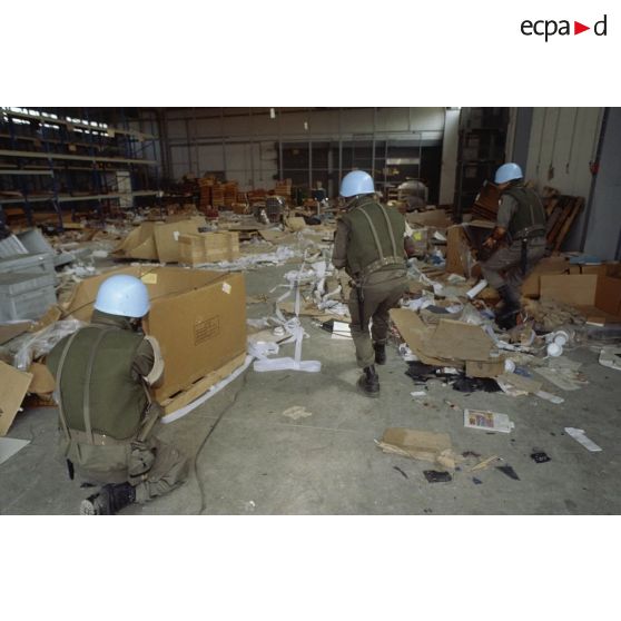 Des marsouins du 2e RIMa pénètrent dans un hangar dévasté de l'aéroport de Sarajevo.