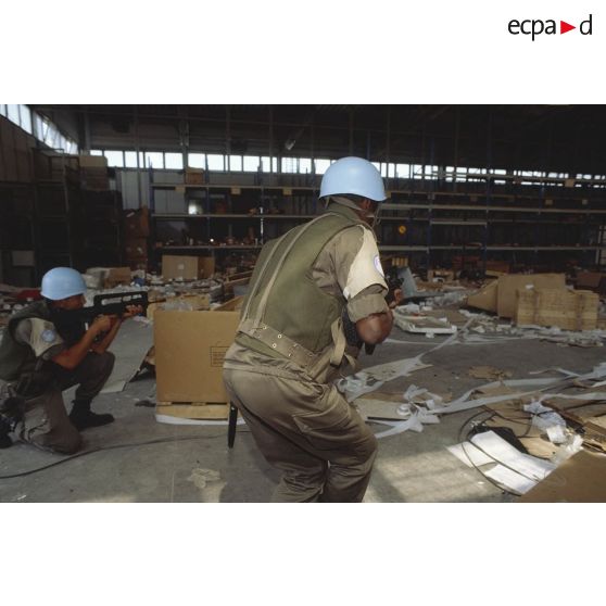 Des marsouins du 2e RIMa pénètrent dans un hangar dévasté de l'aéroport de Sarajevo.