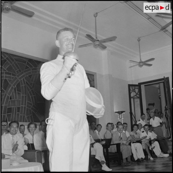 Le vainqueur du championnat militaire d'épée du Nord-Vietnam salue de son arme.