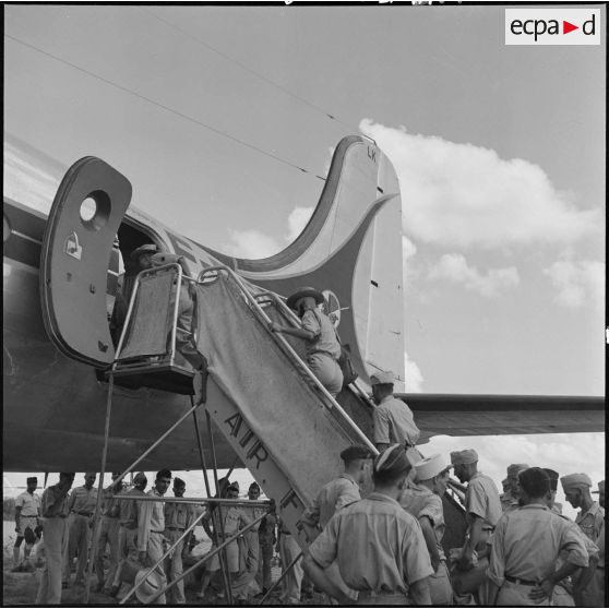 Deux soldats des troupes coloniales embarquent à bord d'un avions pour un pèlerinage à la Mecque.	