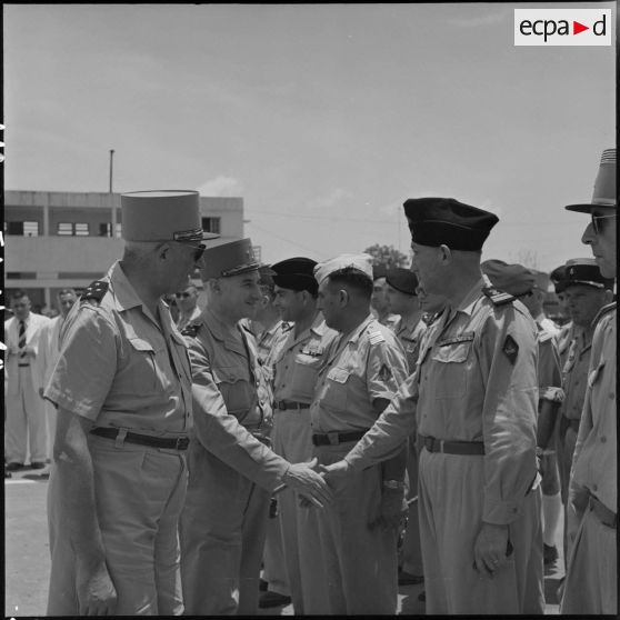 A son arrivée sur l'un des aérodromes d'Hanoï, le général Navarre serre la main d'un officier.