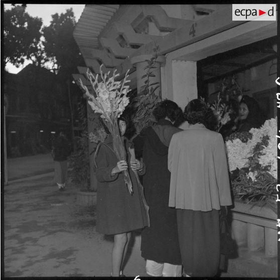 Des femmes achètent des fleurs pour les préparatifs de Noël.