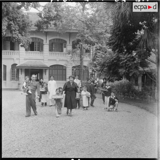 L'épouse du général Cogny (au centre au premier rang), commandant en chef des FTNV (forces terrestres du Nord-Vietnam), devant une bâtisse lors d'une fête de Noël.