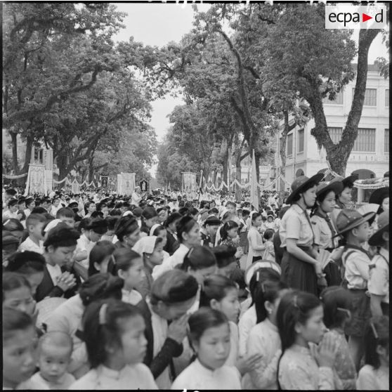 Foule de croyant priant dans la rue lors de la Fête-Dieu à Hanoï.