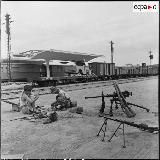 Soldats indochinois et leur armement sur un quai de la gare d'Hanoï.