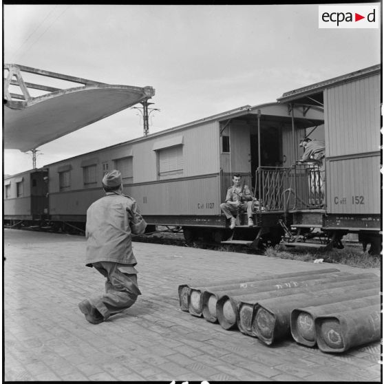 Soldats en attente du départ sur un quai de la gare d'Hanoï.