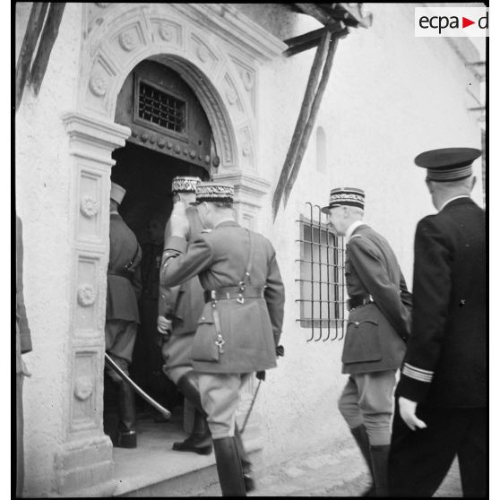 La délégation qui accompagne le général d'armée Henri Giraud, commandant en chef civil et militaire, lors de sa visite à l'EEOI (École des élèves officiers indigènes d'Algérie et de Tunisie) de Bou Saada, pénètre dans le café maure de l'école.