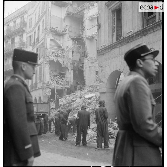 Suite au bombardement allemand de la nuit du 18 au 19 avril 1943, des volontaires de la défense passive déblaient des gravats dans une rue donnant sur la place du Gouvernement à Alger.