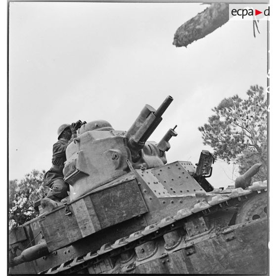 Un chef de char léger Renault D1 observe à la jumelle depuis la tourelle du blindé (armé d'un canon de 47 mm, modèle 1934, et d'une mitrailleuse de 7,5 mm MAC 31 Reibel) dans le secteur de Pichon.