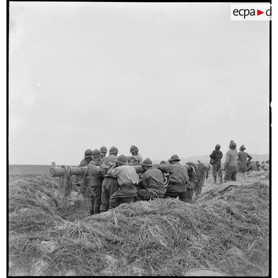 Des artilleurs, pointeurs télémétreurs du 411e RAAA (régiment d'artillerie antiaérienne) de la DMC (division de marche de Constantine), utilisent un télémètre stéréoscopique à échelle variable de batterie de 75 mm dans le secteur de Robaa.