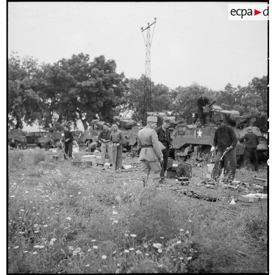 Des chasseurs du 5e RCA (régiment de chasseurs d'Afrique) de la 1re DB (division blindée) inventorient les matériels et lots de bord équipant leurs chars légers Stuart M5 A1 dans un champ en bordure d'une route menant à Blida.