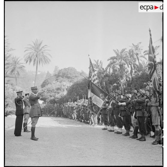 Le général d'armée Henri Giraud, commandant en chef civil et militaire, salue les drapeaux alliés et le drapeau du 1er RZ (régiment de zouaves) au Palais d'été d'Alger.