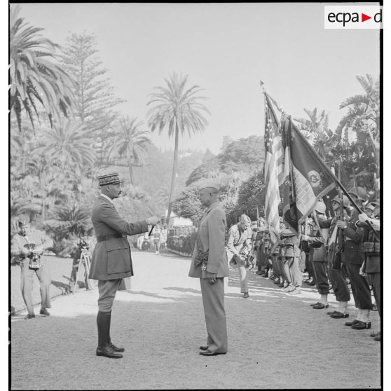 Le général d'armée Henri Giraud, commandant en chef civil et militaire, après avoir remis les insignes de grand-croix de la Légion d'honneur au général Dwight Eisenhower, commandant en chef des forces alliées en Afrique, le frappe du plat de l'épée sur chaque épaule.