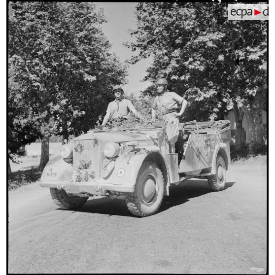 Dans Blida, deux artilleurs du 65e RAA (régiment d'artillerie d'Afrique) posent sur un véhicule de liaison allemand Kfz-15, pris à l'ennemi par l'unité pendant la campagne de Tunisie.