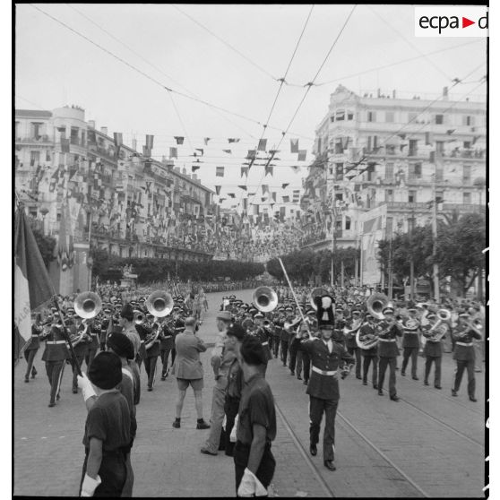 Défilé d'une musique militaire américaine lors du 14 juillet 1943 dans une rue pavoisée d'Alger.