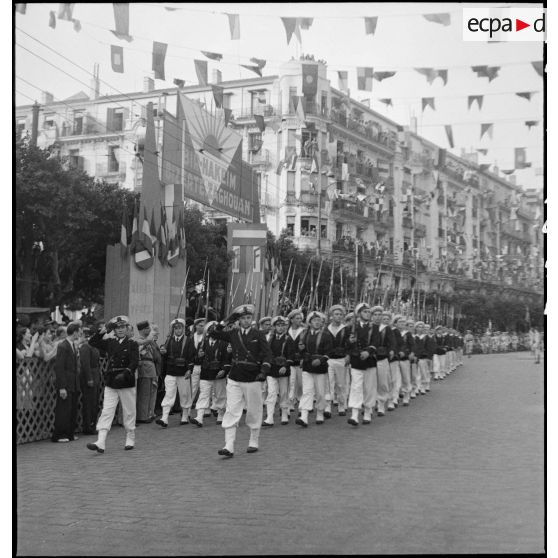 Défilé de fusiliers marins lors du 14 juillet 1943 dans une rue pavoisée d'Alger.