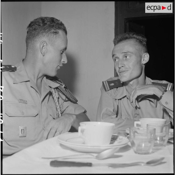 Portrait de deux légionnaires, anciens combattants de la bataille de Diên Biên Phu, au cours d'un repas.