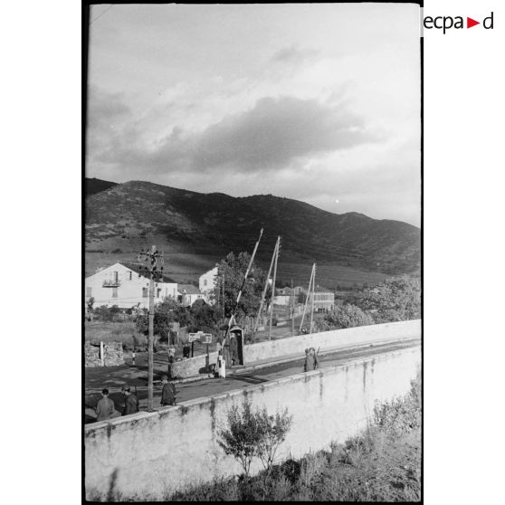 Des soldats italiens contrôlent l'accès d'une route et d'un pont menant probablement à Saint-Florent (intersection des N 197 et N 193, dans la commune de Ponte-Leccia).