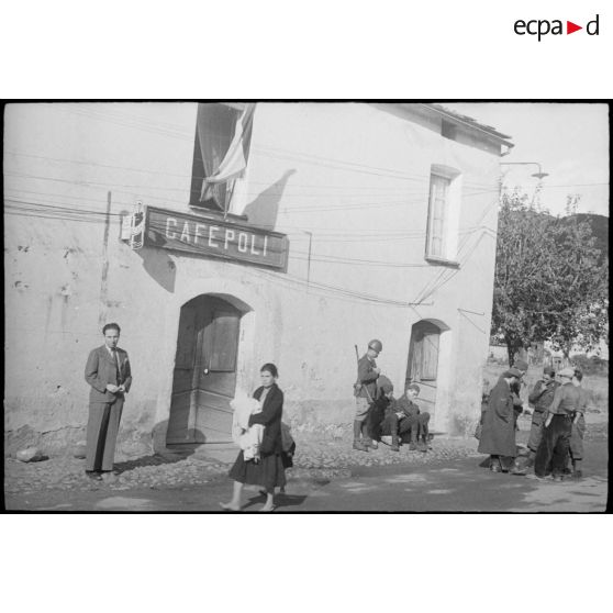 Soldats italiens et population corse près d'un café dans la commune de Ponte-Leccia.