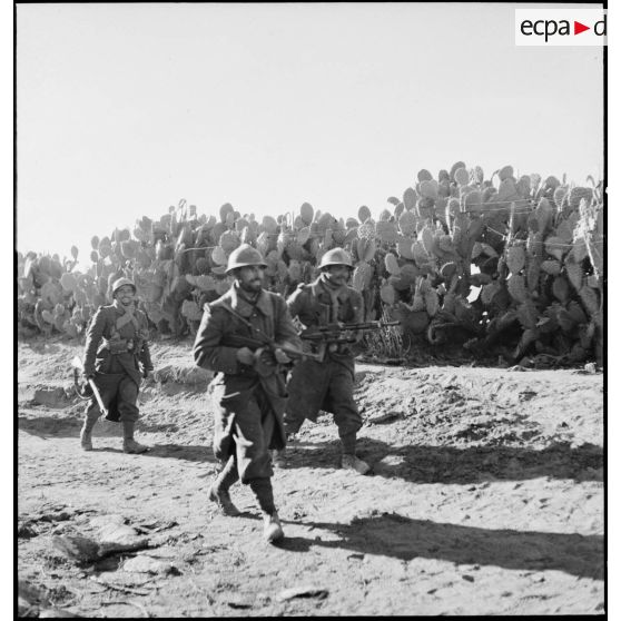 Patrouille de tirailleurs du 9e RTA (régiment de tirailleurs algériens) de la DMC (Division de marche de Constantine) armés d'un pistolet-mitrailleur Thompson M1 avec chargeur circulaire, d'un fusil-mitrailleur FM M 24/29 et d'un mousqueton modèle 1892, postés au milieu de cactus.