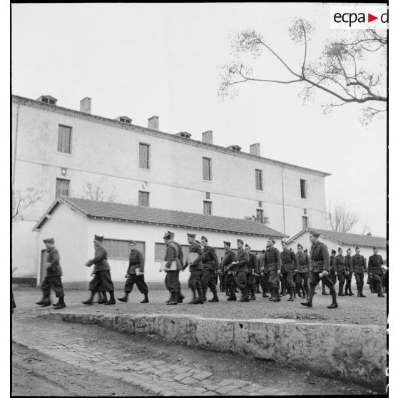 Des élèves sortent en ordre serré d'une salle de cours de l'école des élèves aspirants ou CIEO (Centre d'instruction des élèves officiers) de Cherchell à la caserne Dubourdieu.