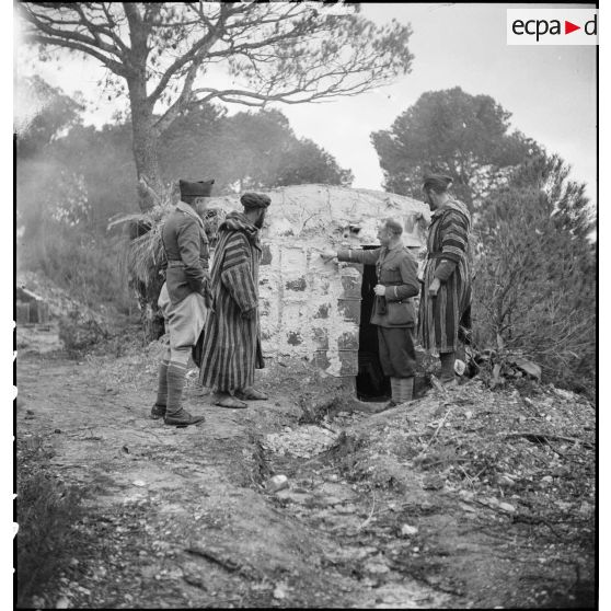 Contrôle par des officiers d'un abri que des supplétifs viennent de construire dans le campement du 1er GSM (groupe de supplétifs marocains) de la 1re DMM (division de marche du Maroc), secteur de Maktar.