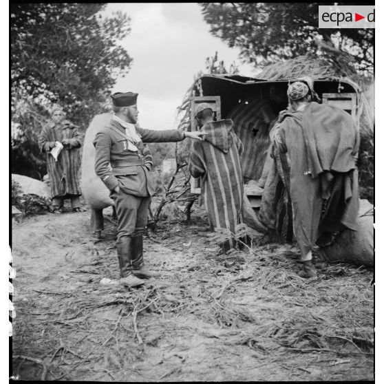 Sous les ordres d'un lieutenant, des supplétifs déchargent du ravitaillement d'un camion dans le campement du 1er GSM (groupe de supplétifs marocains) de la 1re DMM (division de marche du Maroc) dans le secteur de Maktar.