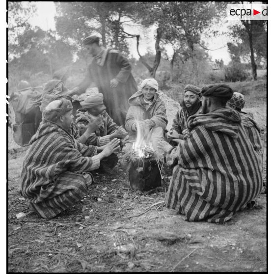 Des supplétifs du 1er GSM (groupe de supplétifs marocains) de la 1re DMM (division de marche du Maroc) discutent autour d'un feu.