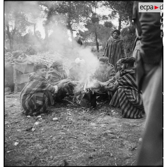 Des supplétifs du 1er GSM (groupe de supplétifs marocains) de la 1re DMM (division de marche du Maroc) discutent autour d'un feu.