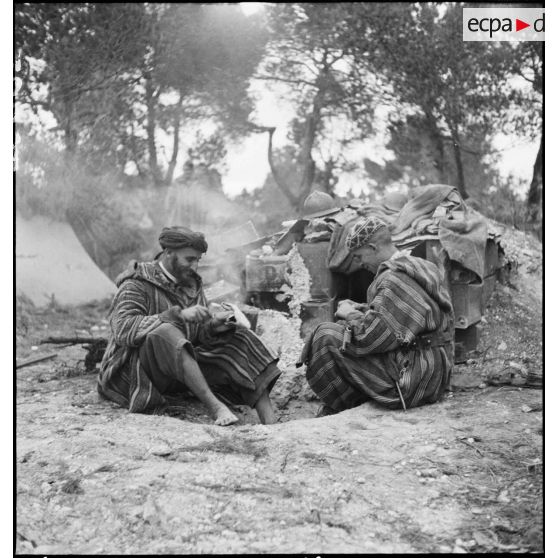 Des supplétifs du 1er GSM (groupe de supplétifs marocains) de la 1re DMM (division de marche du Maroc) se restaurent dans le campement de leur unité.