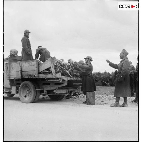 Des tirailleurs du 7e RTA (régiment de tirailleurs algériens) de la DMC (division de marche de Constantine) déchargent des carcasses de moutons d'un camion dans le secteur de Maktar.