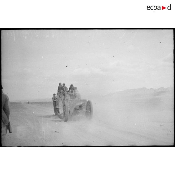 Des soldats français du FSEA (Front sud-est algérien) franchissent, à bord d'un véhicule tractant un canon de 75 mm, modèle 1897, les lignes italo-allemandes du secteur du djebel Bou Jerra, au nord du Chott el Jerid.