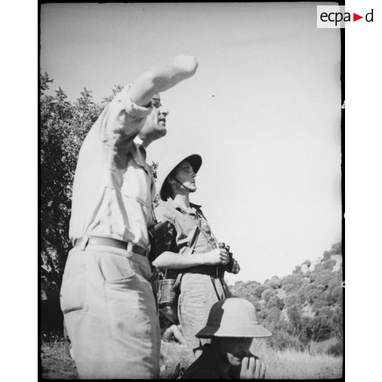 Un élève aspirant de l'école de Cherchell écoute les remarques d'un capitaine instructeur lors d'une école à feu après un tir d'entrainement.