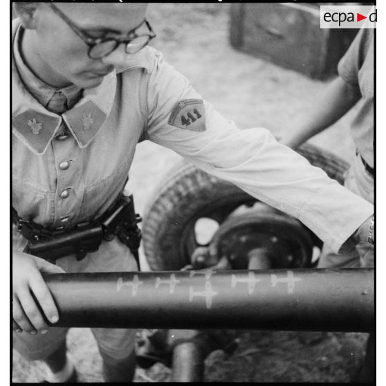 Un élève aspirant du 411e groupement d’artillerie de DCA-DAT (défense contre les aéronefs - défense aérienne du territoire) examine le fût d'un canon de 40 mm Bofors sur lequel figurent des silhouettes d'avions symbolisant le tableau de chasse de la pièce d'artillerie.