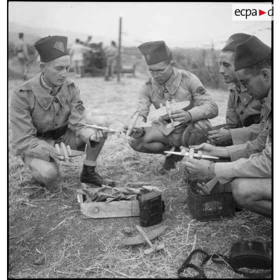 Des élèves aspirants du 411e et du 412e groupement d'artillerie de DCA-DAT (défense contre les aéronefs - défense aérienne du territoire) apprennent à reconnaître les avions amis et ennemis à partir de maquettes.