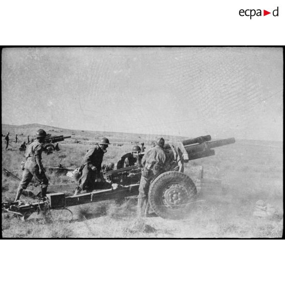 Tir de barrage d'une batterie d'obusiers de 105 mm M2 du 64e RAA (régiment d'artillerie d'Afrique) au cours d'une manoeuvre du CEF (corps expéditionnaire français), avant l'engagement sur le front italien.