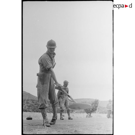 Exercice de déminage avec un détecteur de mines, type poêle à frire, pendant une manoeuvre du CEF (corps expéditionnaire français).