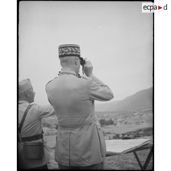 Au cours d'une tournée d'inspection auprès du CEF (corps expéditionnaire français), le général d'armée Henri Giraud, commandant en chef civil et militaire et coprésident du CFLN (comité français de la Libération nationale), observe une manoeuvre de la grande unité aux jumelles.