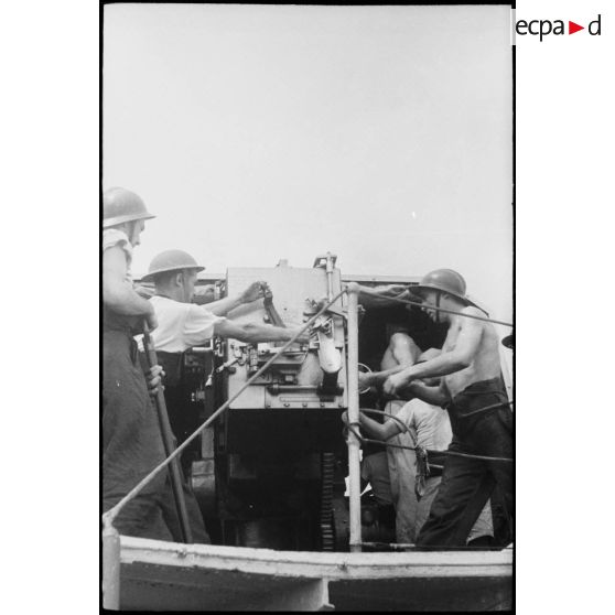 Des marins canonniers sont à leur poste de combat sur un des navires du convoi à destination de la Corse.