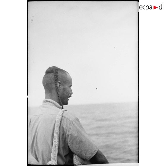 Profil d'un tirailleur du 1er régiment de tirailleurs marocains (RTM) sur le pont d'un navire naviguant vers la Corse.