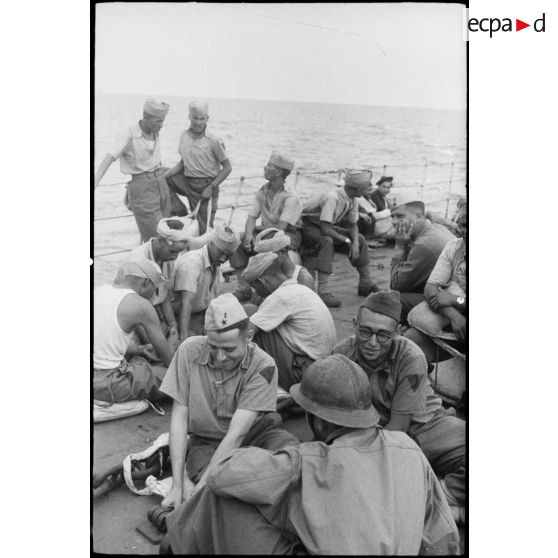 Des tirailleurs du 1er régiment de tirailleurs marocains (RTM) sont rassemblés sur le pont avant d'un torpilleur ou contre-torpilleur à destination de  la Corse.